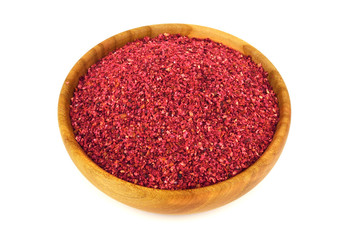 Ground Sumac Spice in Wooden Bowl. Isolated on White Background.