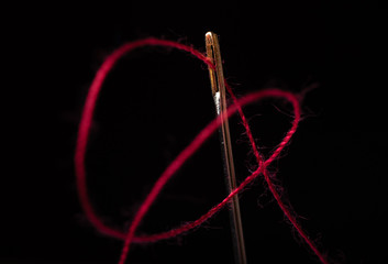 needle and thread on a black background