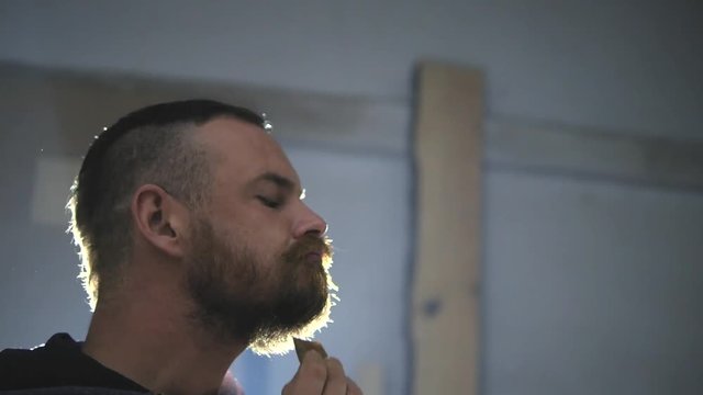 mustache carpenter twists his mustache, bearded carpenter laughing