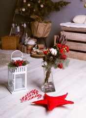 Christmas composition of a bouquet and a flashlight with candles on the background of the Christmas tree. Decorations to celebrate the New Year and Christmas