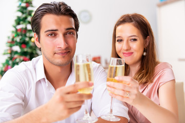 Young couple celebraring christmas with champagne