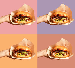 Woman hands hold big cheese burger barbeque sandwich with marble beef on purple