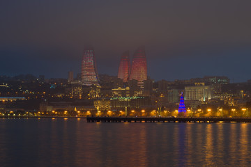 Fototapeta na wymiar View of the city embankment on a foggy winter evening, Baku