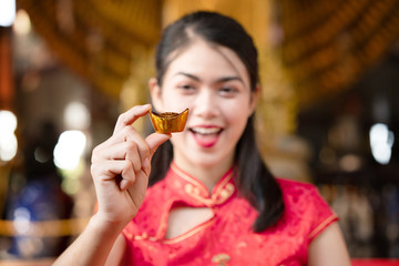 Close up hand woman holding piece of gold weighing ten baht. Pure gold The gold is stored, Considered a good asset. Play high-risk gold stocks should also have expert advice. Gift in Chinese New Year