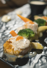 closeup scallop steak on black dish