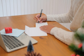 man writing christmas letter greeting card holiday wishes with xmas decoration