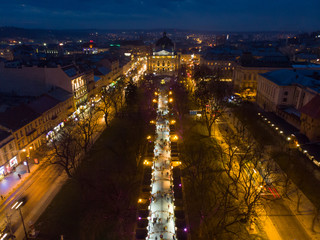 Fototapeta na wymiar overhead view of european city in night time. people walk by fair in evening
