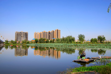 Unfinished building and anglers in a park, China