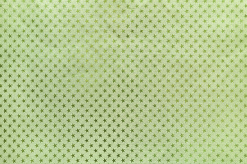 Light green background from metal foil paper with a stars pattern