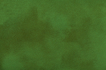 Dark green matte background of suede fabric, closeup.