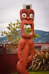 Maori statue with open mouth and big eyes in Rotorua, New Zealand