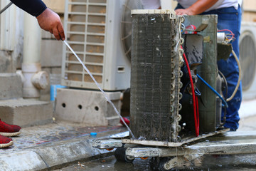 Worker to cleaning coil cooler of air conditioner by water for clean a dust on the wall in customer...