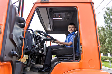 Boy sitting behind the wheel fire engine