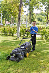 Cute smiling boy working with lawn mower