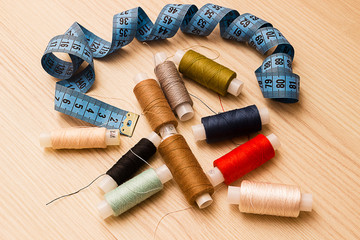 Blue measuring tape and multicolored thread spools