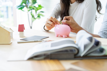 Happy couple plan buying house.Concept for Couple saving money for buy home and real estate. Select material for decorate furniture.