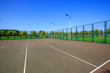Tennis court fence and street lamp