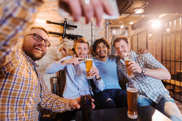 Four friends taking self portrait at pub.