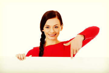 Beautiful student woman pointing on blank board