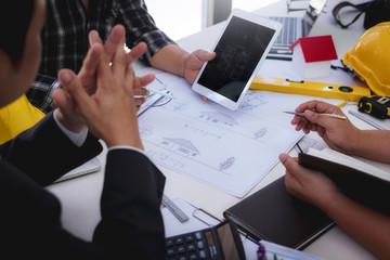engineer people meeting working and pointing at a drawings in office for discussing. Engineering tools and construction concept.