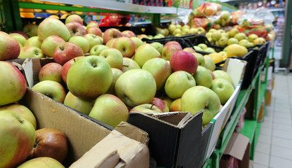 Fresh apples on store shelves in boxes.