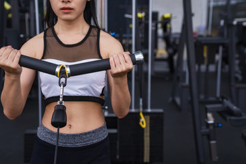 Fototapeta na wymiar fitness woman exercise workout with exercise-machine Cable in fitness gym. healthy lifestyle Concept