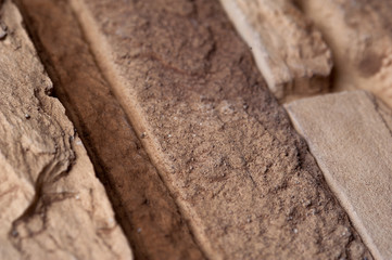 Stone wall of natural stones in different sizes. Rustic stone veneer in shades of brown color. Wall covering with natural stones
