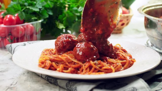Serving spaghetti with meatballs in tomato sauce