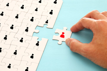 image of puzzle with people icons over wooden table ,human resources and management concept.
