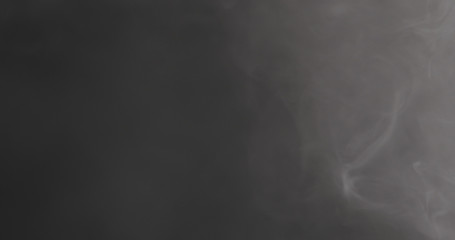 Slow motion closeup vapor floating in air on black background