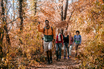 Man showing other hikers right way while walking in woods.
