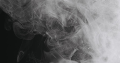 Slow motion closeup vapor floating in air on black background