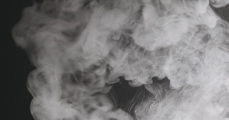 Slow motion closeup vapor floating in air on black background