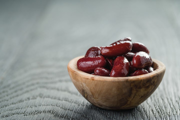 red canned beans in wood bowl on wood background