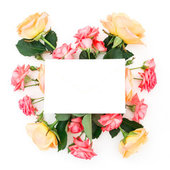 Composition with pink and orange roses flowers, buds and card on white background. Flat lay, top view