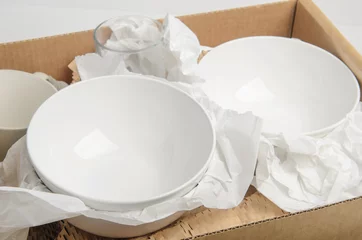 Foto auf Acrylglas Fertige gerichte Sauberes weißes Geschirr in Papier verpackt in einem Karton. Konzeptumzug.