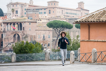 Handsome young sportsman jogging in Rome city