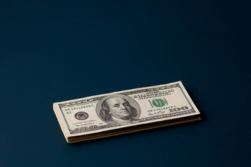 stack of dollars on a dark background with copyspace