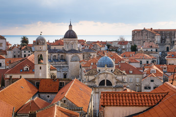Fototapeta na wymiar View over the orange roofs of old town Dubrovnik with church towers and ocean in winter, Croatia