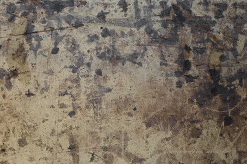 Dark brown spots on the surface of beige cardboard.