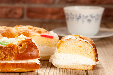 Spanish typical dessert of epiphany  cut piece close-up and porcelain cup on brick