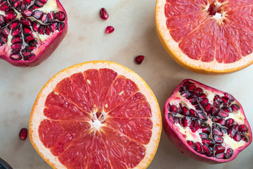 pomegranate and red orange on white marble table
