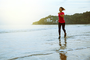 Woman jogging workout on the beach in the morning. Relax with the sea walk. Jump up and fun on workout.