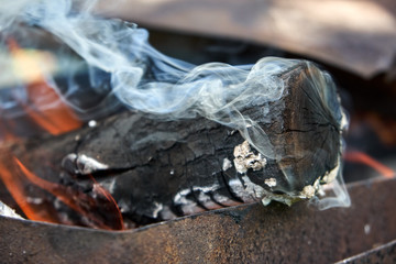 Burning logs in the grill, smoking log