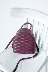Burgundy leather backpack on white wooden chair, womens leather backpack