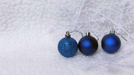 New year, christmas greeting card. Three blue christmas-tree ball on shiny snow background.