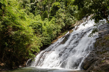 Fototapeta na wymiar Beautiful waterfall flowing through a tropical rain forest in Thailand (Ton Prai, Lam Ru, Thailand)