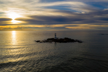 Fototapeta na wymiar Aerial drone view of a lighthouse and beautiful tropical sunset over the ocean