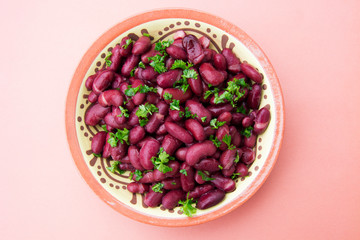Cooked red beans plate on pink background, isolated. Healthy food.