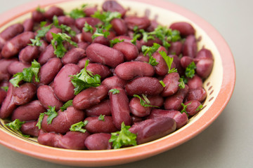 Cooked red beans plate on pink background, isolated. Healthy food.